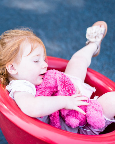 toddler with hot pink bunny spin at playground
