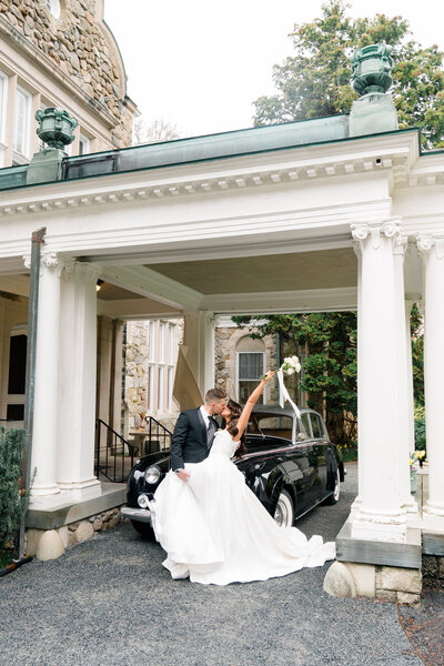 Wedding Photographer Newport RI | Rhode Island Caprio Captured Photography | Bride In a Silk Gown Leaning On The Groom In A Black and White Tux In Front of A Vintage Car