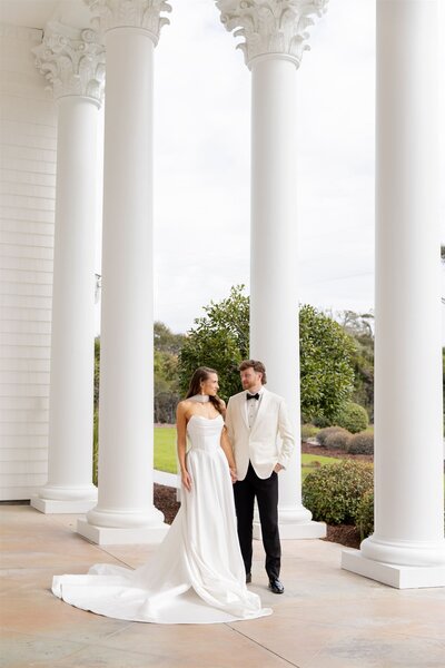 Elegant wedding portraits of bride and groom at a classic Raleigh venue with white columns, filmed and photographed by Raleigh wedding photographer and videographer Moments by Hiba.