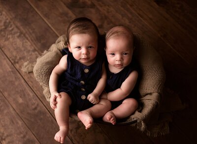 Twin four month old boys posed in bucket.