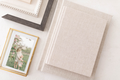 Framed image of a mother and daughter styled with gold and wood frame corners on a Kansas City photographer’s display table.