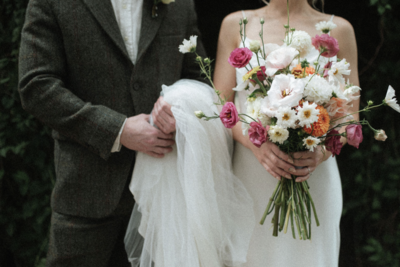 bride and groom holding flowers and wedding dress in Brooklyn, nyc. New york city wedding photographer. 