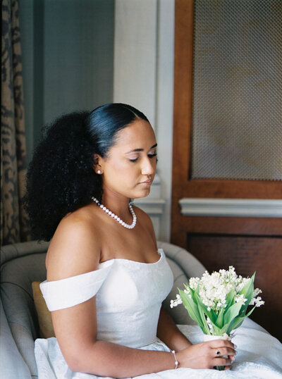 Film image of a bride wearing her white wedding dress holding her floral bouquet on her wedding at St. Regis Hotel in Washington DC.