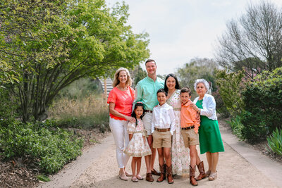 a family of five sitting on a park at coker arboretum and having their photo taken by rosa ashdown