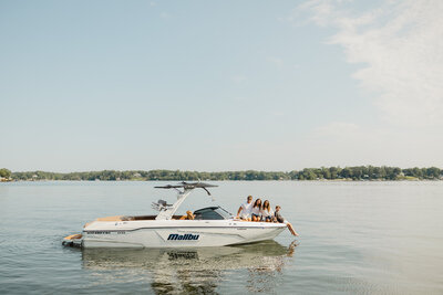 a family sitting on the front of a boat out on the water 
