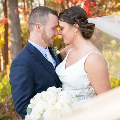 bride and groom embrace while smiling at camera