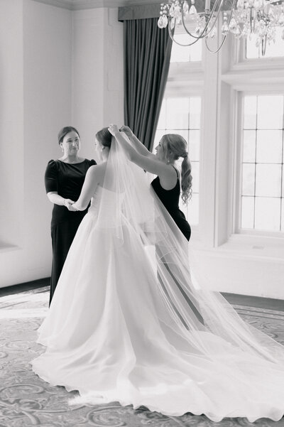 bridesmaid attaches brides veil