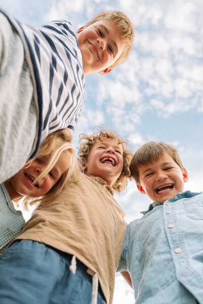 Group of kids smiling and laughing outside on a sunny day