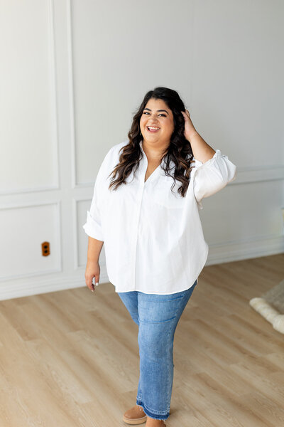 Marissa Martinez smiling and wearing a white top and blue jeans