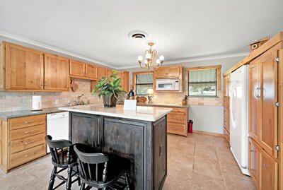 Open kitchen with island at this 3-bedroom, 2-bathroom vacation rental home with large fenced yard, firepit, and dock access with incredible views of Lake Whitney.