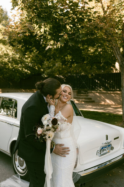 Bride and groom by vintage car