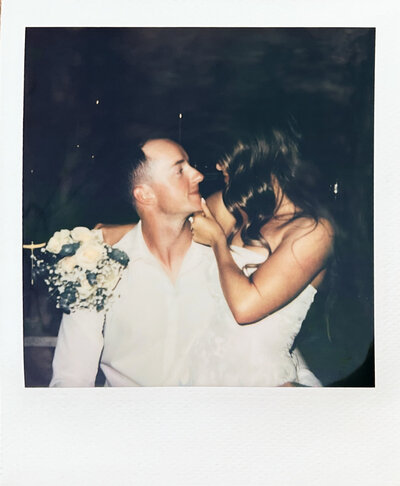 polaroid photo of a couple hugging while inside a dark speakeasy bar