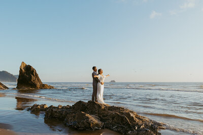 couple doing titanic pose on rock at oregon coast