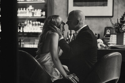 Moody black-and-white Sunshine Coast elopement photo of newlyweds sharing a kiss at their reception.