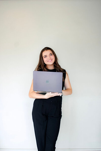 Leilah Smiling Holding a Computer