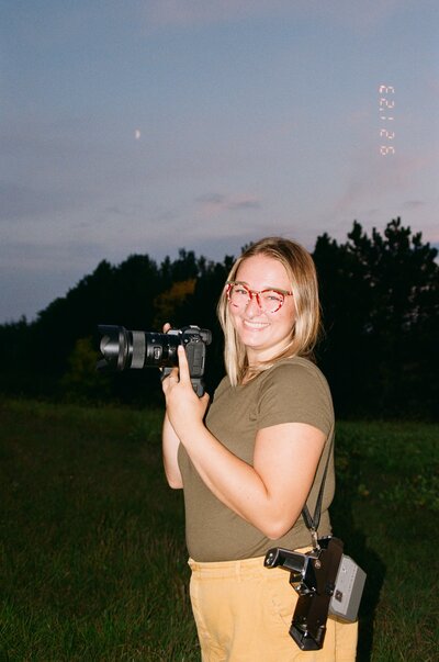 brianna kirk film portrait smiling holding a digital and super 8 camera at blue hour