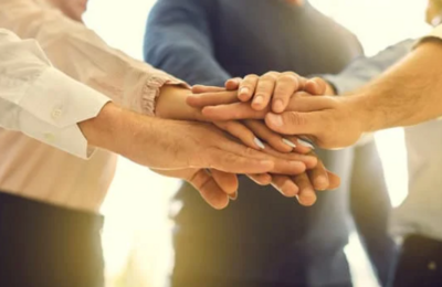 Low angle  close  up of people stacking hands making agreement; studioroman