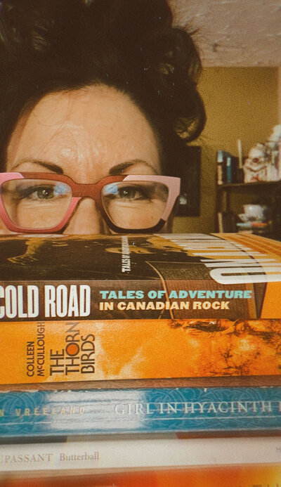 Barb with half her face covered by a stack of books