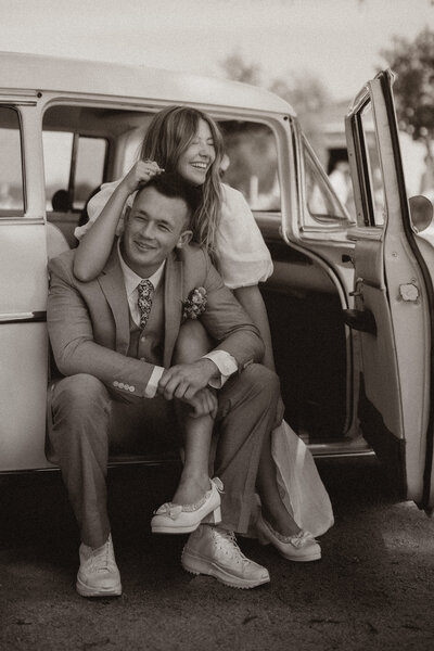 bride and groom holding eachother in the car