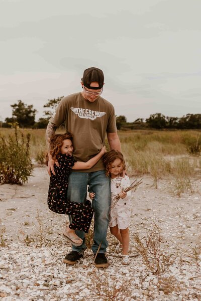 Dad at beach with daughters.
