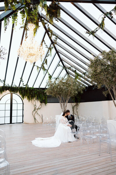 Bride and groom sitting on chairs during a photoshoot