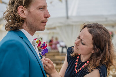 Florist Anna Sawle attaching the grooms buttonhole of gloriosa, vanda orchid and yellow crespedia