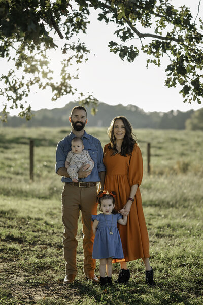 Family poses for their portrait at sunset at O5 Farms in Jefferson, Georgia