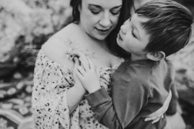 Black and white image of mom and son holding hands.