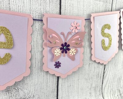 Close up pink butterfly baby shower banner with pink and purple flowers