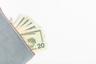 An image of twenty dollar bills coming out of a wallet as a stock image
