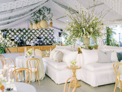 ursuline convent tented wedding in new orleans with banquette lounges, rattan pendant lights, and greenery trellises