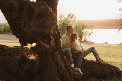 Couple sitting together on a tree during a relaxed outdoor session in Pennsylvania