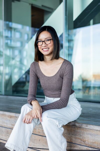 Dark haired woman with black glasses smiling