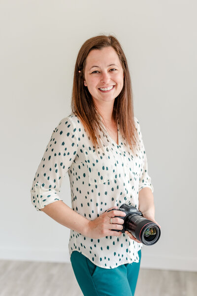 newborn photographer holding camera and smiling in Fargo