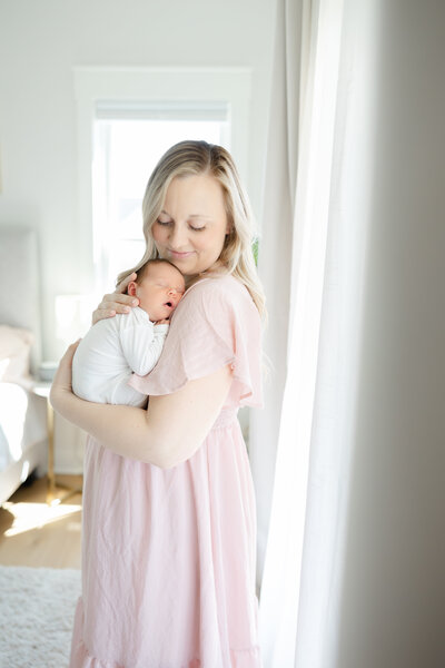 mom snuggling newborn sleeping baby during newborn photos