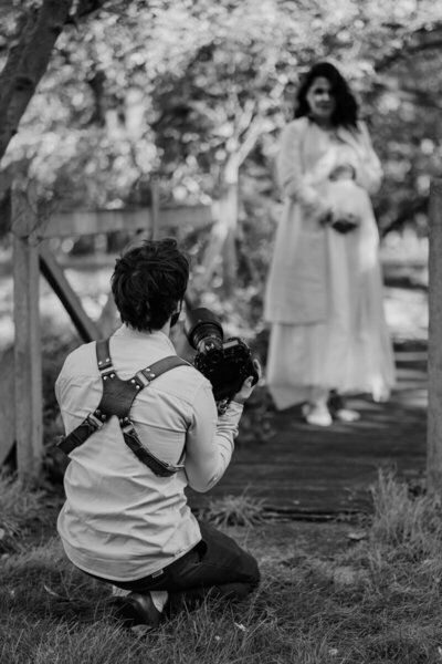 Tom Keenan squatting on the floor ready to photograph a bride at her wedding at Childerley