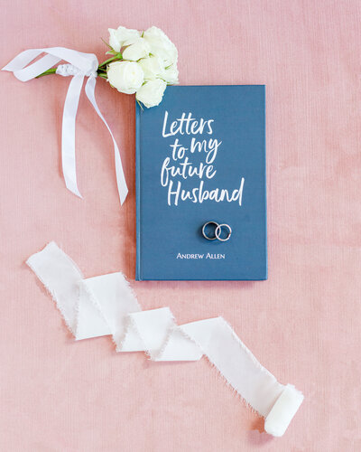 Detail flat lay photo in Boone, NC of a notebook, rings and flowers on a wedding day.