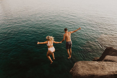 man & woman jumping into water