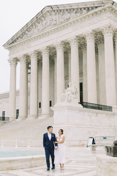 engaged bride and groom stand together outside of the Jefferson Memorial in Washington DC