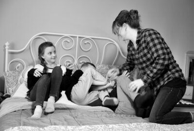 Mom and kids playing on bed  | Family Session
