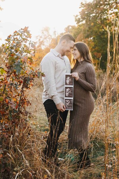 Joyful outdoor maternity session cpatured in the glowing fall light