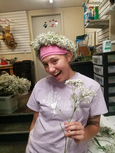 Pittsburgh wedding florist Heavenly Blooms wearing a flower crown and holding a stem of flowers