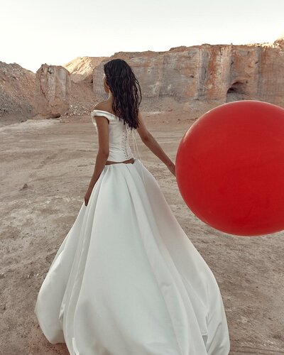 Kyha Bride 'Nevada' wedding dress stocked at Sunday's Bride, London. UK. Embrace your inner whimsy in the cloud-like KYHA BRIDE 'Opal skirt'. A feat in construction, this sculptural masterpiece is adjustable in length, giving you the option to take Opal from floor length opulence, to playful knee length, to even a powder puff strapless dress. Cut from duchess satin, Opal takes this season's most sought-after on-and-beyond the runway silhouette to new couture level.