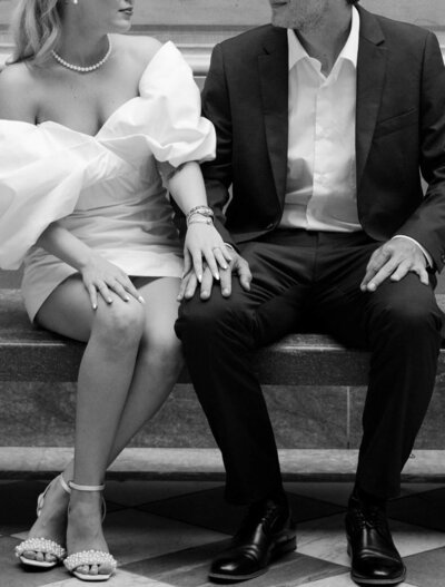 The groom and the bride are sitting on the steps, holding hands