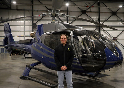young pilot front of blue luxurious ec 130 b4 helicopter