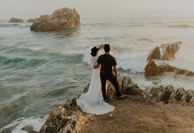bride and groom holding each other by the ocean