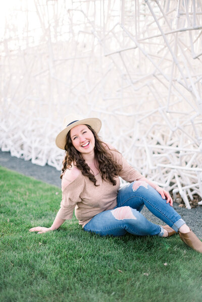 Girl sitting in the grass a nd laughing