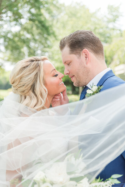 couple on wedding day with veil around them