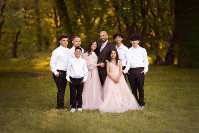 Dallas family photography session of a family with seven members, including children, outdoors during sunset.