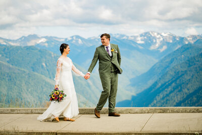 husband and wife hold hands at hurricane ridge at olympic national park elopement